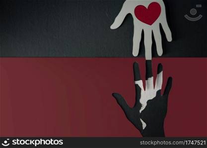 Donation Concept. Help, Care, Love, Support or Partnership. Paper Cut as Hands Shape hanging on the wall. look like the top one with a Red Heart trying to help the one below