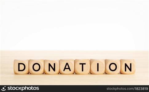 Donation word on wooden block shape. Copy space. White background