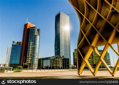Donau City, Vienna, / Austria - 01, August 2013: View at Modern yellow wooden sculpture Austria Center in Donau City. DC Tower 1 and Andromeda tower in background.. Austria Center in Donau City