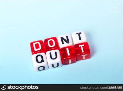 Dont Quit Do It written on red and white dices on blue background