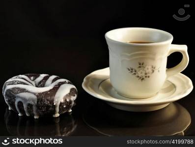 donut and cup of coffee on black background