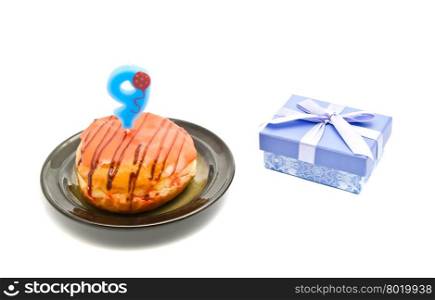 donut with nine years birthday candle and gift on white background