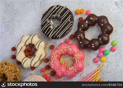 Donuts decorated icing and sprinkles on white background top view