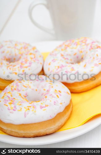 Donuts With Colorful Sprinkles, Plates and Mugs on Table - Shallow Depth Of Field