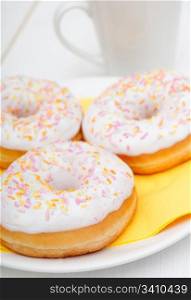 Donuts With Colorful Sprinkles, Plates and Mugs on Table - Shallow Depth Of Field