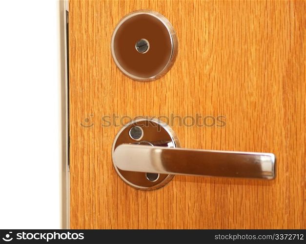 Door. A metalic door handle on a wooden door