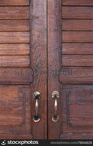 door handle. Brown wooden door. The door handle is aluminum.