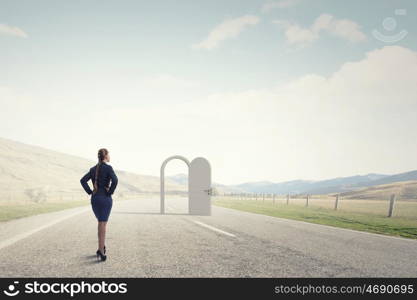 Door to new opportunity. Businesswoman standing in front of opened doors and making decision