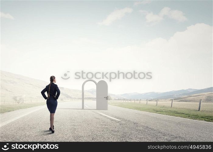 Door to new opportunity. Businesswoman standing in front of opened doors and making decision