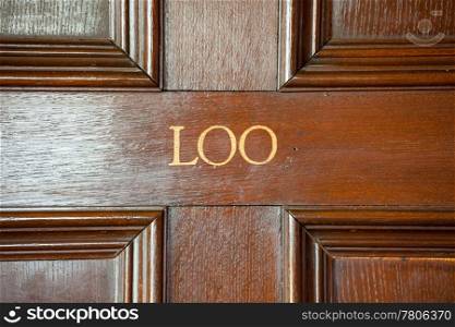 Door to restroom with word Loo painted onto wooden door