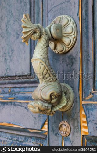 Doorknocker in the form of a fish on an old door