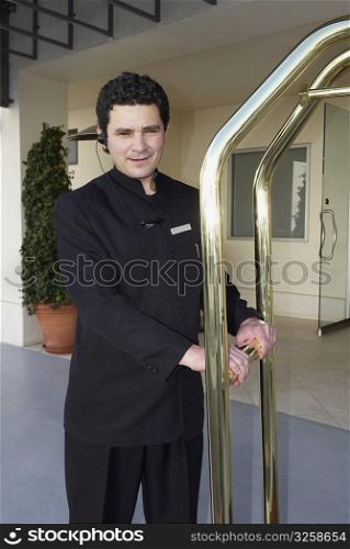 Doorman holding a luggage cart