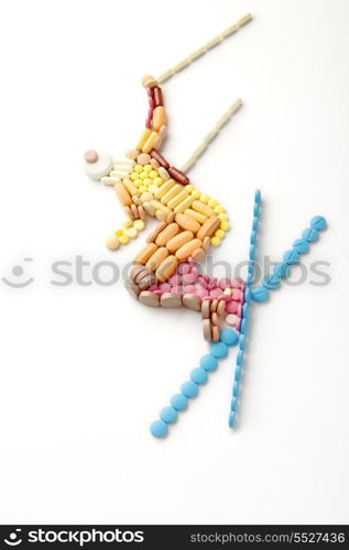 Doping pills and drugs in the shape of a winter jumping skier.