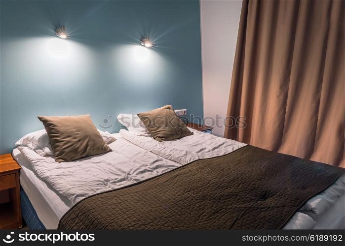Double bed with pillows and shining lamps