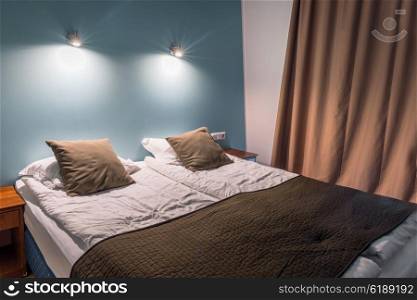 Double bed with pillows and shining lamps