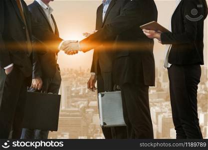 Double exposure business people handshake agreement with cityscape in background. Business executive meeting and collaboration.. Double exposure Business People Handshake Meeting