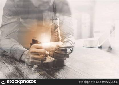 Double Exposure,businessman using smart phone and keyboard dock digital tablet.Worldwide network connection technology interface.on wooden desk,sun flare effect