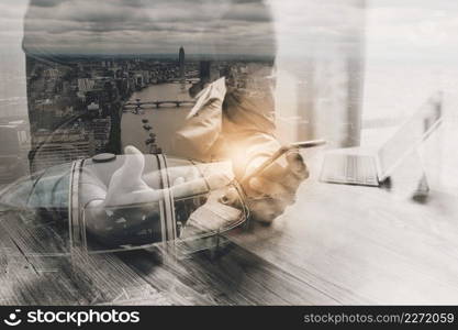 Double Exposure,businessman working with new start up project.using smart phone digital tablet docking smart keyboard on wooden desk,sun effect