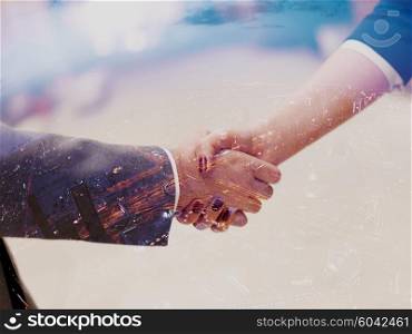 Double exposure design. Business partners concept with businessman and businesswoman handshake at modern office indoors