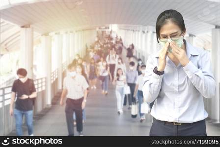 Double Exposure image of Asian worker or business woman wearing surgical mask hands covered her mouth while coughing with blurred of crowed,Wuhan coronavirus (COVID-19) outbreak prevention.