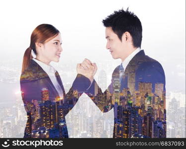 double exposure of arm wrestling between businessman and businesswoman with a city background