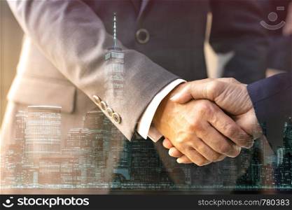 Double exposure of business Handshake with new york manhattan skyline building background