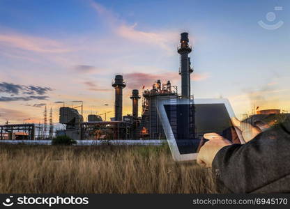 Double exposure of businessman checking oil refinery industry plant by tablet in the night as Energy and Technology concept