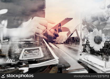 Double exposure of businessman hand using mobile payments online shopping,omni channel,laptop computer on wooden desk,glass vase flowers,London architecture buildings
