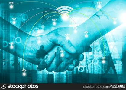 Double exposure of businessman handshake and business district background, connections concept. Elements of this image furnished by NASA.