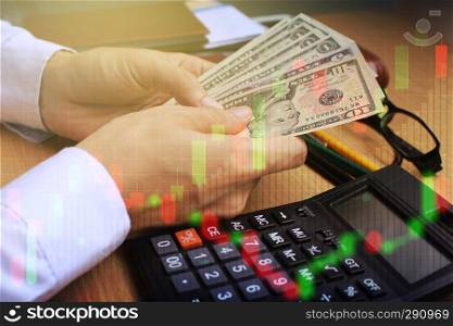 Double exposure of businessman use Counting dollar money with stock market or financial graph for financial investment concept.