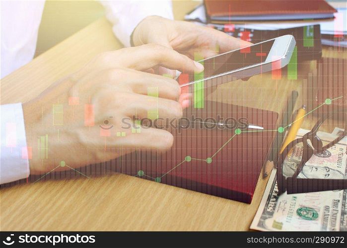 Double exposure of businessman use smartphone with stock market or financial graph for financial investment concept.