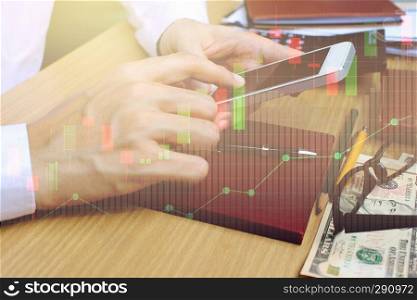 Double exposure of businessman use smartphone with stock market or financial graph for financial investment concept.