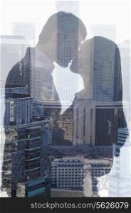 Double exposure of couple kissing over cityscape