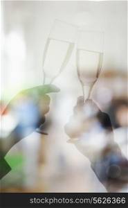 Double exposure of couple toasting with champagne flutes