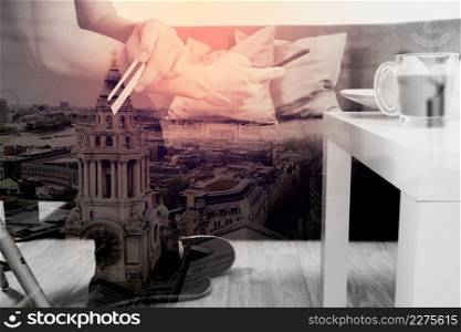 double exposure of hipster hand using smart phone,digital tablet docking keyboard,holding cradit card payments online business,sitting on sofa in living room,work at home concept,London architecture city