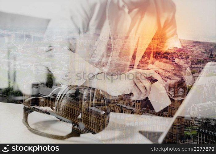 double exposure of hipster hand using smart phone,digital tablet docking keyboard,holding credit card payments online business,sitting on sofa in living room,work at home,London architecture city