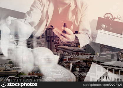 double exposure of hipster using smart phone and digital tablet computer and holding credit card payments online business,sitting on sofa in living room,work at home concept,London architecture city