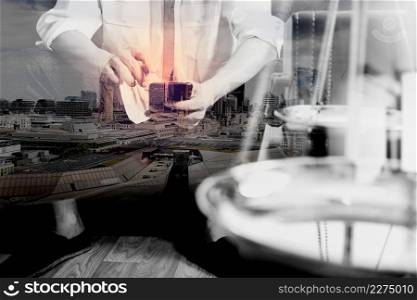 Double exposure of Justice and Law context.Male lawyer hand sitting on sofa and working with smart phone,digital tablet computer docking keyboard with gavel and document on living table at home,London architecture city