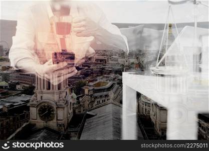 Double exposure of Justice and Law context.Male lawyer hand sitting on sofa and working with smart phone,digital tablet computer docking keyboard with gavel and document on living table at home,London architecture city