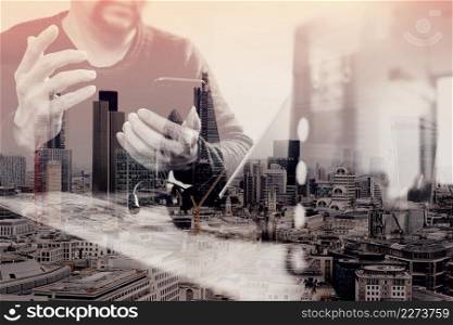 double exposure of man hand using VOIP headset with digital tablet computer docking keyboard,smart phone,concept communication, it support, call center and customer service help desk with compact server at foreground,London architecture city