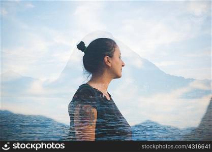 Double exposure of mid adult woman looking out at Lake Lugano, Switzerland
