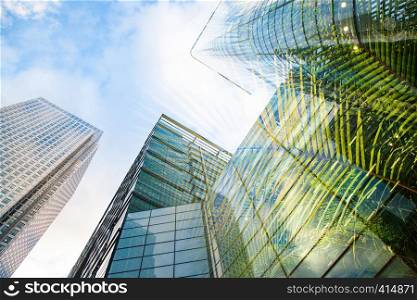 double exposure of modern skyscrapers windows and lush green vegetation - eco friendly green city