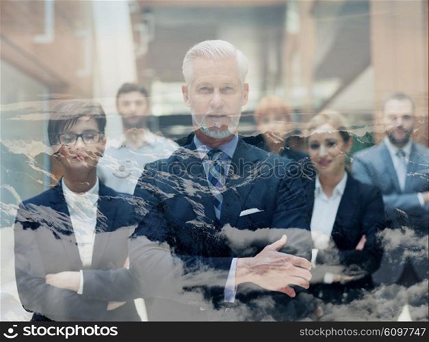 double exposure of senior businessman with his team at office. multi exposure of business people group and clouds and mountains nature