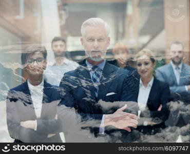 double exposure of senior businessman with his team at office. multi exposure of business people group and clouds and mountains nature