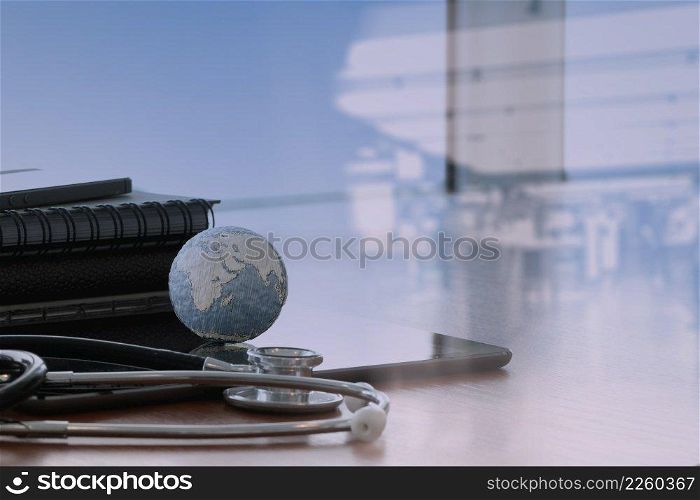 double exposure of stethoscope and texture globe with digital tablet as medical network concept