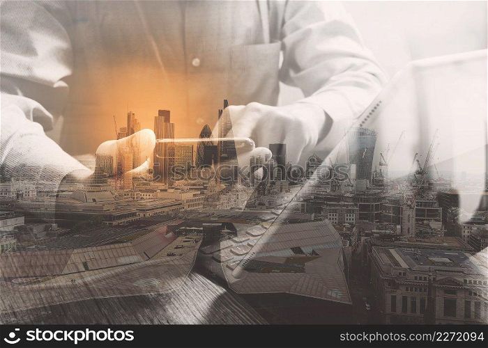 Double exposure of success businessman using smart phone,digital tablet docking smart keyboard  with London building,city,omnichannel