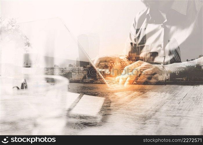 Double exposure of success businessman using stylus pen,digital tablet docking smart keyboard  with London building,city,filter effect