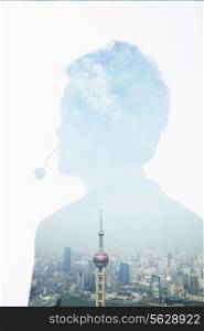 Double exposure of young businessman with headset and the skyline of Shanghai, China