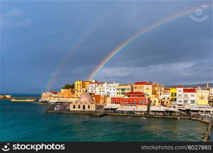 Double rainbow in a cloudy sky above old harbour of Chania with Venetian quay and Kucuk Hasan Pasha Mosque in summer day, Crete, Greece