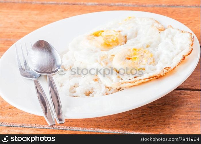 Double star eggs topped on rice with spoon and fork